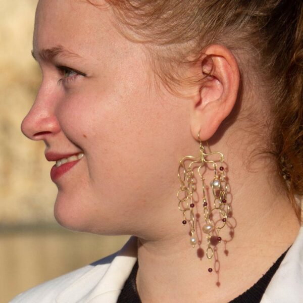 Dangling designer gold waterfall earrings worn side view