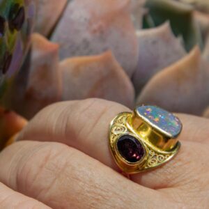Sustainable gold filigree opal and garnet ring worn